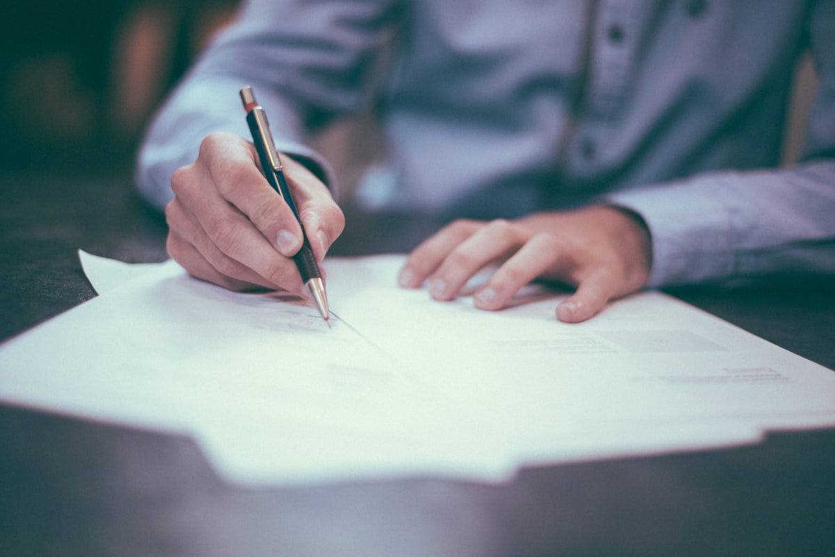 Hands reviewing an employment contract at a desk